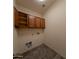 Compact laundry room featuring tile floors, wall-mounted cabinets, and washer/dryer hookups at 1381 E Prickly Pear Dr, Casa Grande, AZ 85122