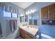 Bathroom featuring a single sink vanity, mirror, lighting, and window at 17810 N 34Th Pl, Phoenix, AZ 85032