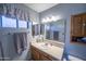 Bathroom featuring a single sink vanity, mirror, lighting, and window at 17810 N 34Th Pl, Phoenix, AZ 85032