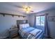 Bedroom featuring a striped bed, ceiling fan, side table, and natural lighting from the window at 17810 N 34Th Pl, Phoenix, AZ 85032