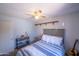 Cozy bedroom with striped bedding, ceiling fan, wood-look floor, and gray accents at 17810 N 34Th Pl, Phoenix, AZ 85032