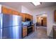 Well-lit kitchen featuring stainless steel refrigerator and wood cabinets at 17810 N 34Th Pl, Phoenix, AZ 85032