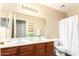 Bathroom with double sinks, a large mirror, and a shower with a white shower curtain at 18774 N Ibis Way, Maricopa, AZ 85138