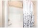 Clean white tiled shower and tub with a patterned shower curtain and neutral walls at 18774 N Ibis Way, Maricopa, AZ 85138
