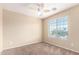 A simple bedroom with a ceiling fan and natural light from the window at 18774 N Ibis Way, Maricopa, AZ 85138