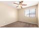 Neutral bedroom featuring a ceiling fan, window and carpeted floor at 18774 N Ibis Way, Maricopa, AZ 85138