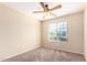 Bright bedroom with a ceiling fan, large window and soft carpet flooring at 18774 N Ibis Way, Maricopa, AZ 85138