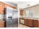 View of kitchen featuring stainless steel refrigerator, wood cabinets, and stainless steel double sink at 18774 N Ibis Way, Maricopa, AZ 85138