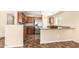Kitchen boasts stainless steel appliances, wood cabinetry, tile flooring, and a breakfast bar at 18774 N Ibis Way, Maricopa, AZ 85138