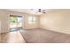 Spacious and bright living room with sliding glass door to the backyard and neutral carpeting at 18774 N Ibis Way, Maricopa, AZ 85138