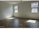 Bedroom with wood-look tile flooring and two windows for natural light at 24105 W Bowker St, Buckeye, AZ 85326
