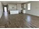 Open-concept living space with wood-look tile flooring and kitchen view at 24105 W Bowker St, Buckeye, AZ 85326
