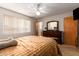Bright bedroom with light walls, warm-toned bedding, and a window with blinds at 509 N 56 St, Mesa, AZ 85205