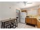 Kitchen featuring white appliances, warm wood cabinets, and a breakfast bar area at 509 N 56 St, Mesa, AZ 85205