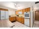 Functional kitchen featuring wood cabinetry, white appliances, and ample counter space at 509 N 56 St, Mesa, AZ 85205