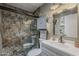Updated bathroom features a walk-in shower with stone-look tiling and modern vanity at 6433 E University Dr, Mesa, AZ 85205