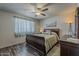Comfortable bedroom featuring a ceiling fan, light-filtering curtains, and nice wood flooring at 6433 E University Dr, Mesa, AZ 85205