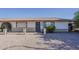 Charming single-story home boasts a well-maintained gravel yard and a secure gated entrance with decorative ironwork at 6433 E University Dr, Mesa, AZ 85205