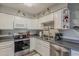 Well-lit kitchen featuring white cabinetry, stainless steel appliances, and functional layout for easy meal preparation at 6433 E University Dr, Mesa, AZ 85205