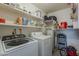 Laundry room with washer, dryer, shelving and water heater at 6433 E University Dr, Mesa, AZ 85205