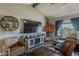 Comfortable living room features a vaulted ceiling, stylish furniture, and a decorative fireplace with a large screen TV at 6433 E University Dr, Mesa, AZ 85205