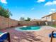 Backyard with a kidney-shaped swimming pool, brick pavers, and privacy fence at 12547 W Edgemont Ave, Avondale, AZ 85392