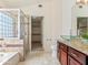Bathroom featuring dual glass sinks, granite counters, and a step-in shower with glass blocks at 12547 W Edgemont Ave, Avondale, AZ 85392