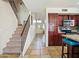 Hallway featuring a staircase, tiled flooring, and a glimpse of the kitchen at 12547 W Edgemont Ave, Avondale, AZ 85392