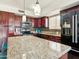 Spacious kitchen featuring a granite island, dark wood cabinets, mosaic backsplash, and stainless appliances at 12547 W Edgemont Ave, Avondale, AZ 85392