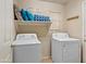 Bright laundry room with washer, dryer, storage shelf and cute wall decor at 12547 W Edgemont Ave, Avondale, AZ 85392