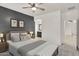 Modern bedroom featuring a gray accent wall, ceiling fan, and stylish decor at 1380 W Angus Rd, San Tan Valley, AZ 85143