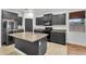 Stylish kitchen with dark cabinets, stainless steel appliances, and a functional center island with sink at 1380 W Angus Rd, San Tan Valley, AZ 85143