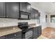 Close-up of a kitchen featuring modern appliances, dark cabinets, and granite countertops at 1380 W Angus Rd, San Tan Valley, AZ 85143