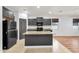 Well-lit kitchen featuring dark cabinetry, a center island, and tile flooring, creating a modern cooking space at 1380 W Angus Rd, San Tan Valley, AZ 85143