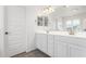 Bathroom featuring dual sinks, a large mirror, and white cabinetry at 14241 W Bronco Trl, Surprise, AZ 85387