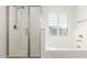 Bright bathroom showcases a glass shower, soaking tub, and a window at 14241 W Bronco Trl, Surprise, AZ 85387