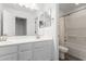 Bright bathroom with double sink vanity and a shower over tub combination with shower curtain at 14241 W Bronco Trl, Surprise, AZ 85387