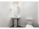 Clean half-bathroom featuring a pedestal sink, and a modern toilet at 14241 W Bronco Trl, Surprise, AZ 85387