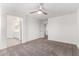 Large bedroom with ceiling fan and a view of the adjacent bathroom at 14241 W Bronco Trl, Surprise, AZ 85387