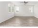 Large living space with neutral paint, wood-style tile flooring and bright light at 14241 W Bronco Trl, Surprise, AZ 85387