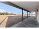 Expansive covered patio with concrete flooring and sturdy support columns, offering a versatile outdoor space at 15582 W Jomax Rd, Surprise, AZ 85387