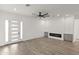 Bright, open-concept living room with wood floors, modern fireplace, and stylish ceiling fan at 15582 W Jomax Rd, Surprise, AZ 85387