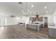 Open-concept living space with modern lighting, fireplace, wood floors, and kitchen at 15582 W Jomax Rd, Surprise, AZ 85387
