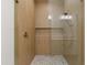 Glass enclosed shower with mosaic tile flooring and natural wood-look walls at 15582 W Jomax Rd, Surprise, AZ 85387