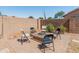 Relaxing backyard fire pit area with chairs, pavers, gravel, and a block wall at 17056 W Bristol Ln, Surprise, AZ 85374