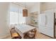 Bright dining area features a checkered tablecloth, open shelving, and a modern drum pendant light fixture at 17056 W Bristol Ln, Surprise, AZ 85374