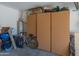 Well-organized garage featuring storage units, water heater, and a bicycle at 17056 W Bristol Ln, Surprise, AZ 85374