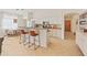 Bright kitchen with white cabinets, stainless steel appliances, tile backsplash, and an island with bar seating at 17056 W Bristol Ln, Surprise, AZ 85374