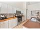 Bright kitchen with white cabinets, stainless steel appliances, tile backsplash, and warm wood countertops at 17056 W Bristol Ln, Surprise, AZ 85374