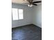 Cozy bedroom featuring a window, fan, and neutral gray tile flooring at 1818 N 63Rd Ave, Phoenix, AZ 85035